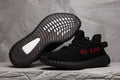 Yeezy Boost 350 V2 Black Knit Trainers with Red Accents - product image from the listing.