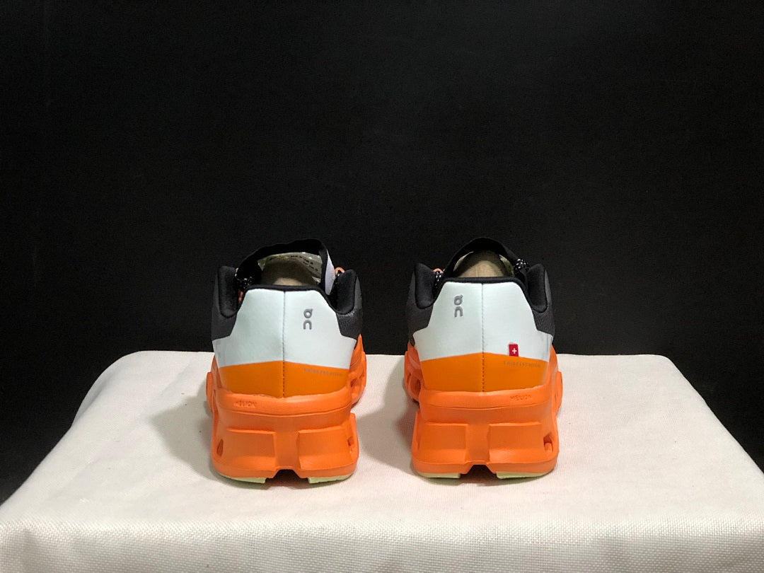 On Cloudmonster Running Shoes in Black Orange - product image from the listing.