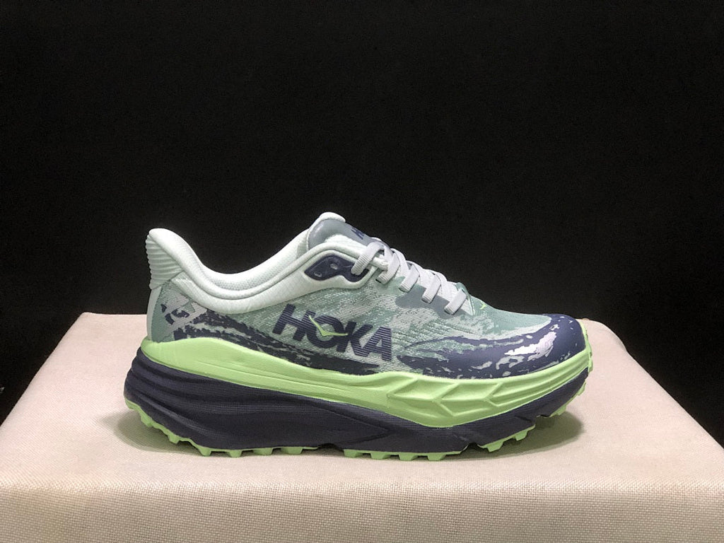 HOKA Stinson 7 Trail Running Shoes, in Green and Navy - product image from the listing.