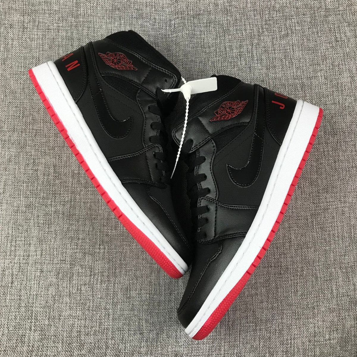 Air Jordan 1 Mid High-Top Sneakers in Black Red White - product image from the listing.