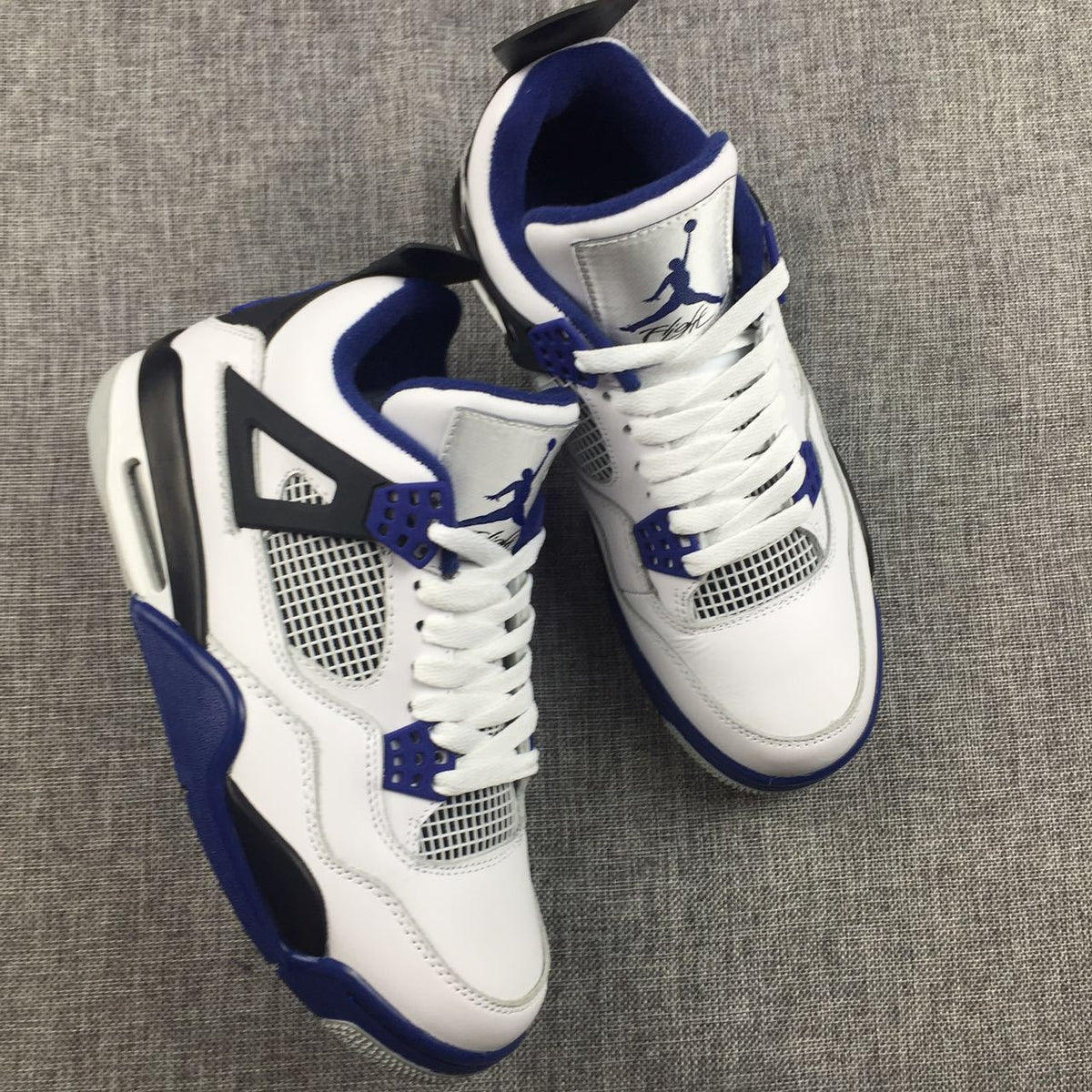 Air Jordan 4 Sneakers in White, Black and Blue - product image from the listing.
