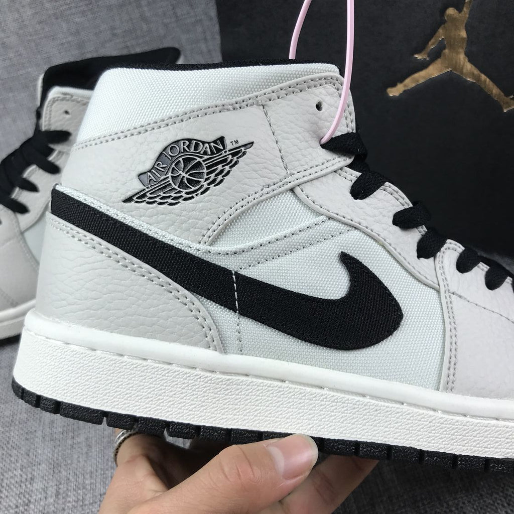 Air Jordan 1 Mid High-Top Sneakers in Grey and Black - product image from the listing.