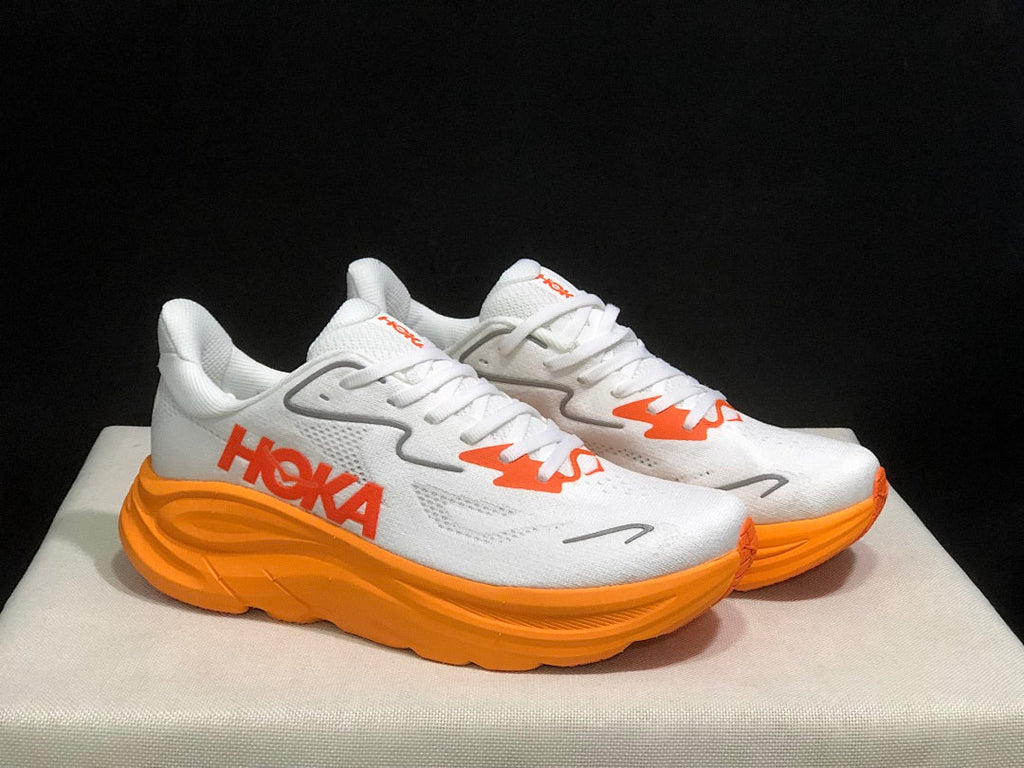 White and Orange HOKA Clifton 10 Running Shoes - product image from the listing.